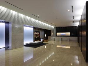 a lobby with a couch and a table in a building at HOTEL UNIZO Osaka Yodoyabashi in Osaka