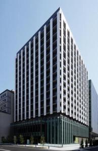 a large office building with a lot of windows at HOTEL UNIZO Osaka Yodoyabashi in Osaka