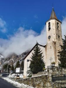 a church with a clock tower on a mountain at Hotel Saurat in Espot