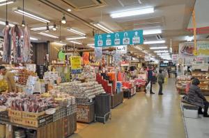 a grocery store aisle with people in a store at City Park Hotel Hachinohe in Minatomachi