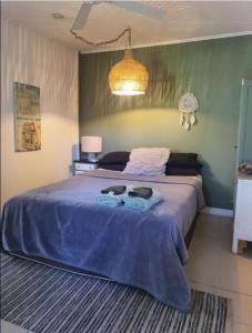 una camera da letto con un grande letto con una coperta viola di Hidden Garden a Cannonvale