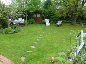 einen Garten mit einer Bank, einem Tisch und Stühlen in der Unterkunft Ferienwohnung Illerhues in Ascheberg