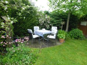 einen Tisch und vier Stühle in einem Garten in der Unterkunft Ferienwohnung Illerhues in Ascheberg