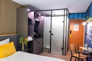 a bedroom with a bed and a table and a kitchen at BeeVillage Messehotel Hannover Laatzen in Hannover