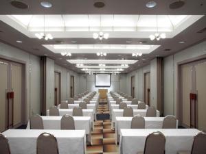 a large room with white tables and chairs and a screen at Villa Kitakaruizawa L-Wing in Tsumagoi