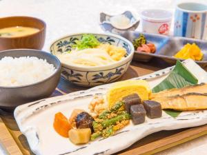 a table with a plate of food and bowls of rice at Osaka Dai-ichi Hotel in Osaka