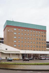 a large building with cars parked in front of it at JR-EAST HOTEL METS NAGAOKA in Nagaoka