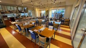 a restaurant with wooden tables and blue chairs at Hotel Crown Hills Arakawaoki in Tsukuba