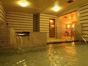 a swimming pool in a building with water in it at Oze Iwakura Resort Hotel in Tokura