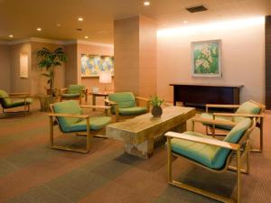 a waiting room with chairs and a table and a piano at Oze Iwakura Resort Hotel in Tokura