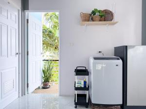 Un refrigerador en una cocina al lado de una puerta. en Sea Dreamer Beachfront Apartments, en Phuket
