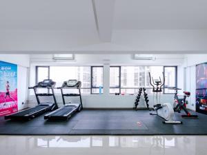 a gym with treadmills and ellipticals in a room at Echarm Hotel - Foshan Sanshui Wanda Plaza in Sanshui