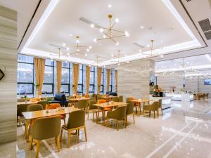 a dining room with tables and chairs and windows at Echarm Hotel - Foshan Sanshui Wanda Plaza in Sanshui