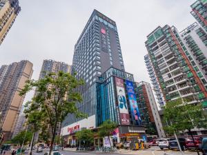 a tall building in a city with tall buildings at Echarm Hotel - Foshan Sanshui Wanda Plaza in Sanshui