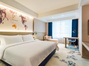 a hotel room with a large bed and a desk at Echarm Hotel - Foshan Sanshui Wanda Plaza in Sanshui +31 photos