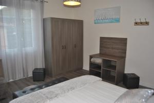 Schlafzimmer mit einem Bett und einem Holzschrank in der Unterkunft Le Calme au Centre Ville à 10 minutes à pied de la Croisette et des plages in Cannes