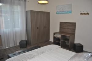 a bedroom with a bed and a wooden cabinet at Le Calme au Centre Ville à 10 minutes à pied de la Croisette et des plages in Cannes