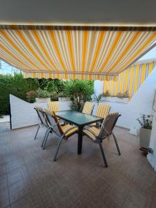 a patio with a table and chairs on a patio at PMT21 Bungalow Cabo Roig in Orihuela