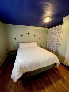 a bedroom with a white bed with a blue ceiling at Hayduke's Hideout in Moab