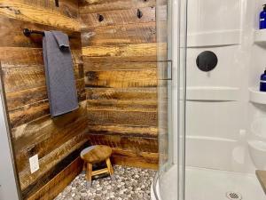a bathroom with a shower with a wooden wall at Hayduke's Hideout in Moab +4 photos
