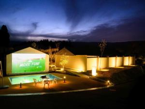 a large building with a swimming pool at night at Kosugi Resort in Aso