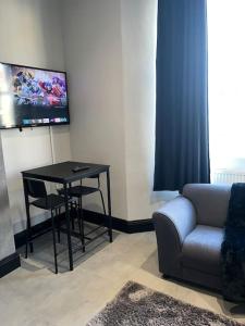 a living room with a table and a couch and a tv at SD Studio Nr Hopetown A1 A19 A66 in Darlington