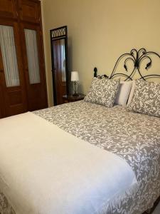 Un dormitorio con una gran cama blanca con almohadas. en Casa Rural La Pitanga, en Hermigua