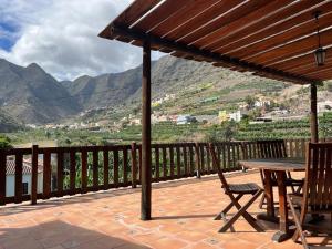 una mesa y sillas en un patio con montañas al fondo en Casa Rural La Pitanga, en Hermigua