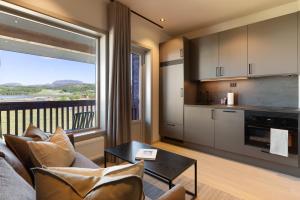 a living room with a couch and a table and a kitchen at Bjugn Hotell in Botngard