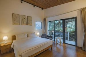 una camera da letto con un letto grande e una grande finestra di Moganshan Linqiguyin Hotel a Fanjiawu Altre 64 foto