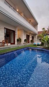 沙努尔Kutus Bali Guesthouse的房子前面的游泳池