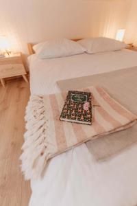 a bed with a blanket and a book on it at Dziewięćsił &Chaber _domki blisko lasu in Grywałd