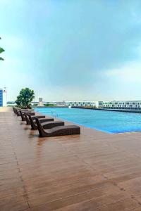 a row of benches sitting next to a swimming pool at Smart Vasanta in Jarakasta