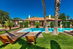 a house with a swimming pool and two palm trees at Villa Monica by BarbarHouse in Polignano a Mare