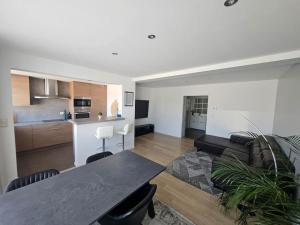 a living room with a black table and a kitchen at Urban Comfort Mechelen in Mechelen