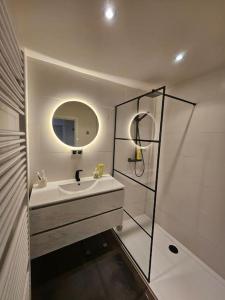 un baño con lavabo y espejo en Urban Comfort Mechelen, en Malinas 18 fotos más
