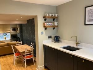 a kitchen with a sink and a table with a counter top at Fab cottage in the heart of Deal - Great Location in Kent