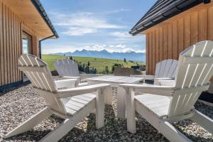 two white chairs sitting on a patio with a table at Nydala Eco in Rzepiska +48 photos