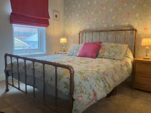 a bedroom with a bed with a floral bedspread at Fab cottage in the heart of Deal - Great Location in Kent +12 photos
