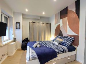 a bedroom with a bed with blue and white sheets at Palais du Luxembourg in Roubaix