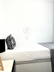 a bed in a room with a white wall at Imperial Villas I Mar y Playa in Puerto del Carmen +5 photos