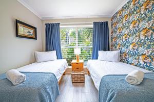 two twin beds in a room with a window at Cozy Garden Unit in Bloubergstrand in Bloubergstrand