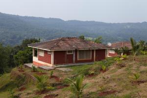 a small house on top of a hill at Bramhagiri Resort in Lānja