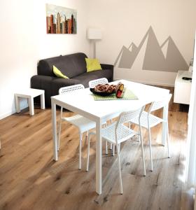 a white table and chairs in a living room with a couch at Da Sandro Holidays Apartment in Arco