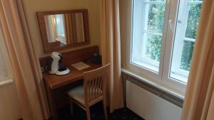Habitación con escritorio, espejo y ventana. en die Villa, Zimmer 23, EZ, en Leverkusen