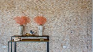 two vases on a table in front of a brick wall at The Villas by LXRYHOME in Jan Thiel +82 photos