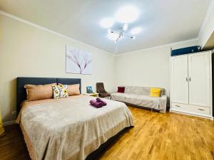 a bedroom with a bed and a couch at Золотой квадрат in Almaty