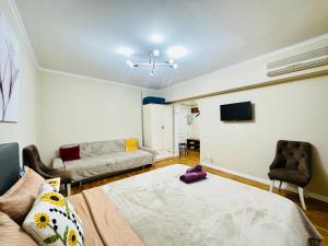 a living room with a bed and a couch at Золотой квадрат in Almaty