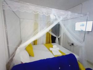 Habitación pequeña con cama con dosel en Esther Goodness Apartments, en Mtwapa