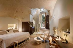 a bedroom with a bed and a desk and a chair at Sant'Angelo - Le Residenze in Matera